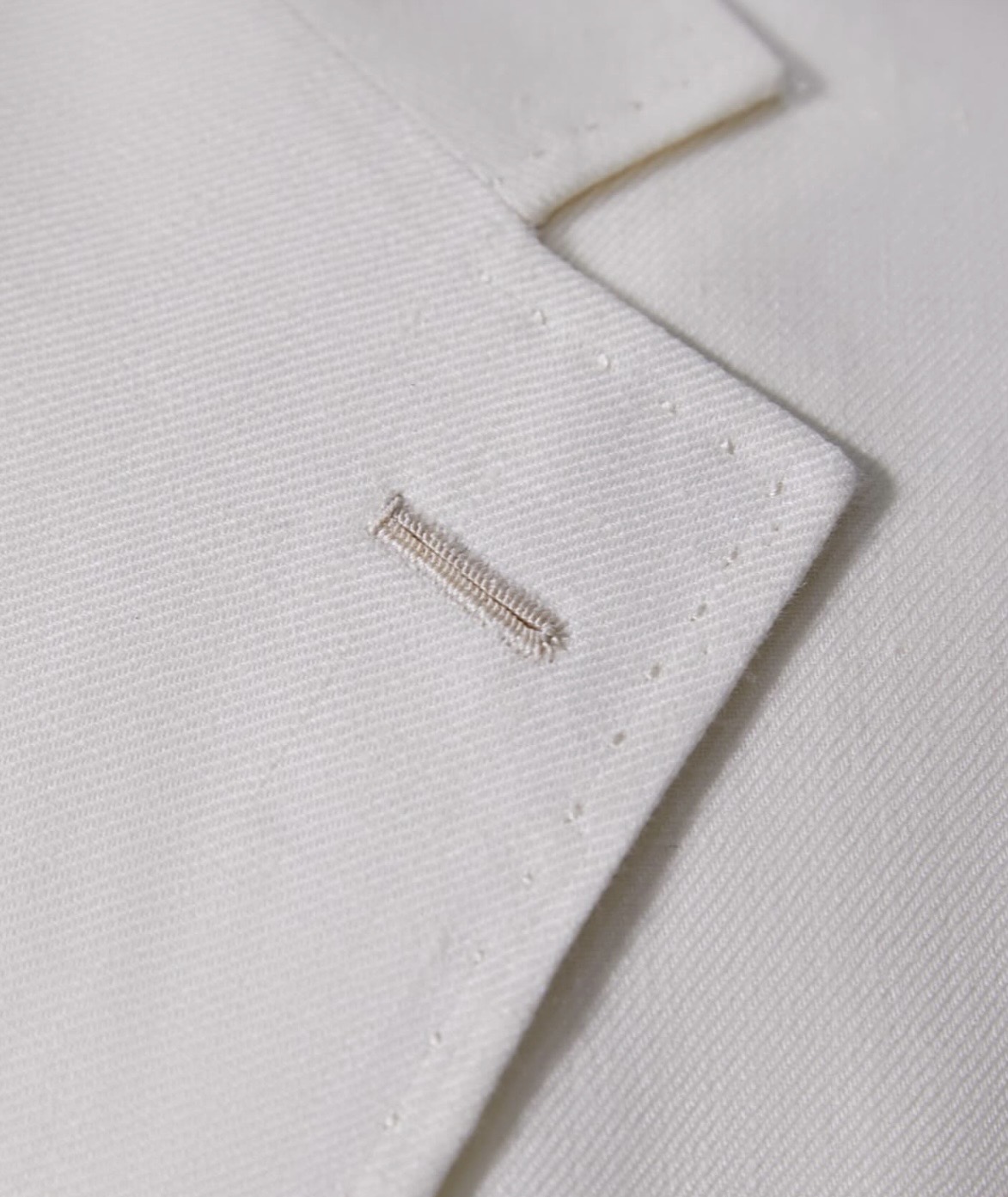 Close-up of precise hand stitching on a bespoke garment